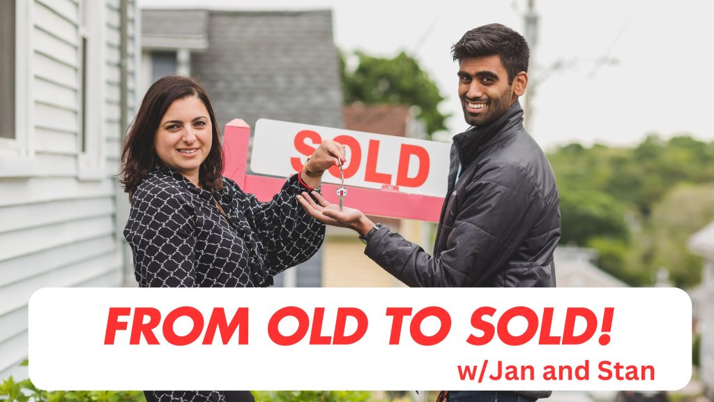two people in front of a Sold Sign, lady passing keys to man